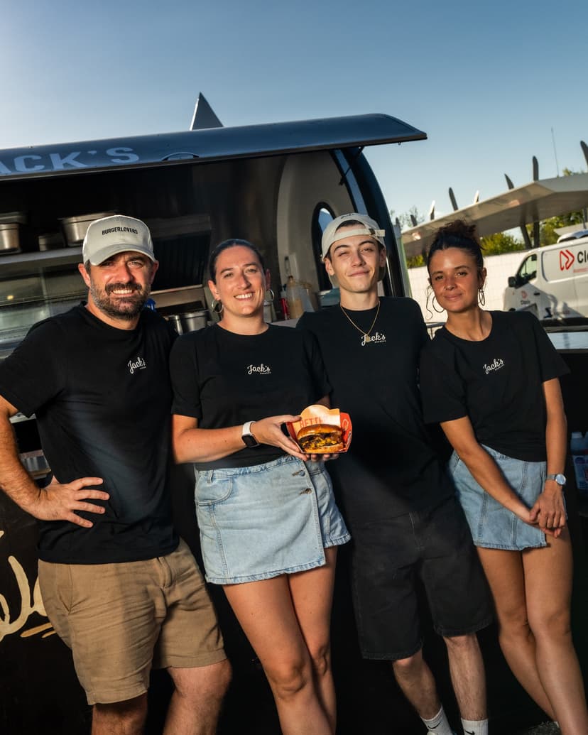 L’équipe de Jack’s Burger devant sa remorque food truck, un burger à la main